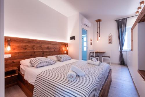 a bedroom with a large bed with two towels on it at Apartments Sole in Komiža