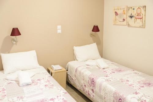 a bedroom with two beds and a night stand at LUX Hotel in Piraeus