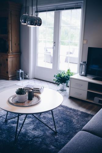 a living room with a coffee table and a tv at Dalhus - House with jacuzzi in Norddal