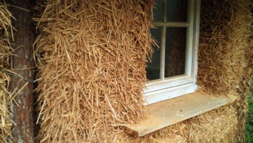 a window in the side of a building covered in hay at Yourte d'Aiguevives in Céré-la-Ronde