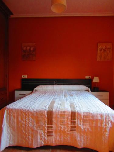 1 dormitorio con 1 cama con pared de color naranja en Casa en ambiente tranquilo y relajante en Garray
