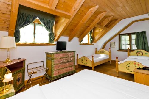 a bedroom with a bed and a room with a bed and a bed sqor at Hotel Edelhof in Tarvisio