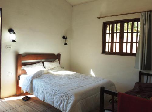 Tempat tidur dalam kamar di Pousada Fazenda São Luiz