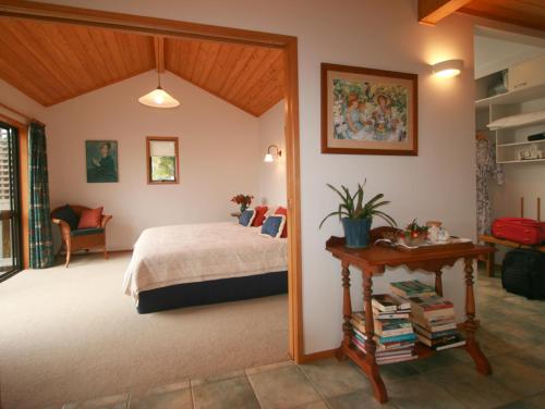 Schlafzimmer mit einem Bett und einem Tisch in der Unterkunft Bay of Islands Cottages in Russell