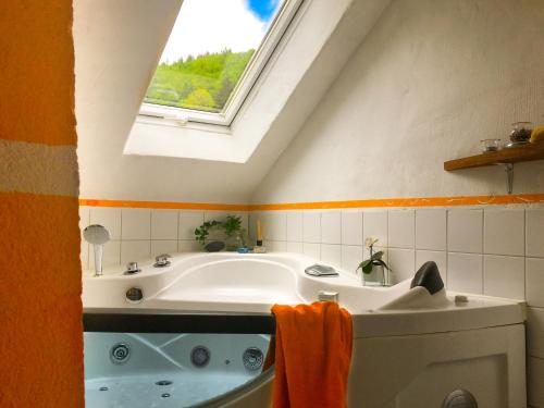 ein Bad mit einer Badewanne und einem Fenster in der Unterkunft Casa Alma in Neuenweg