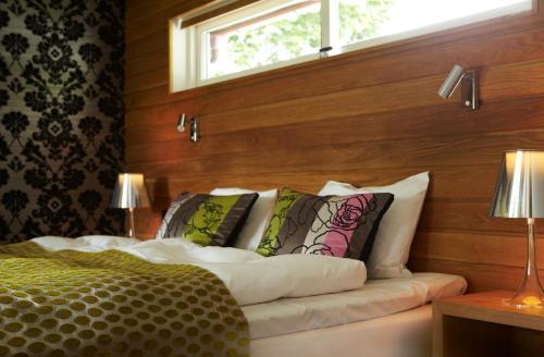 a bedroom with a bed with pillows and a window at Hestraviken Hotell & Spa in Hestra