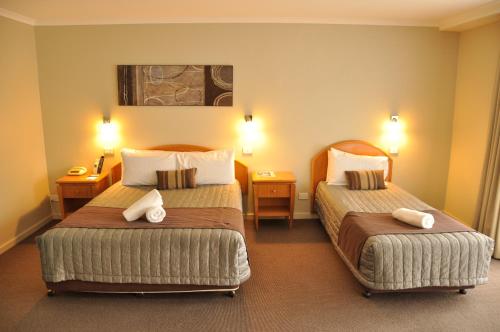 a hotel room with two beds and two lamps at Chittaway Motel in Tuggerah