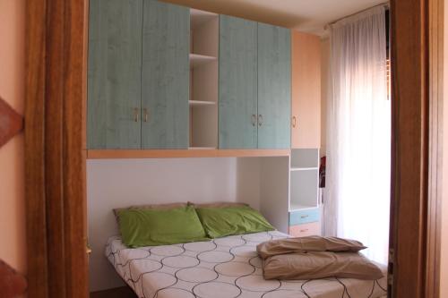 ジャルディーニ・ナクソスにあるCasa Lucrezia Naxos Bayのベッドルーム1室(緑の枕が付いたベッド1台付)
