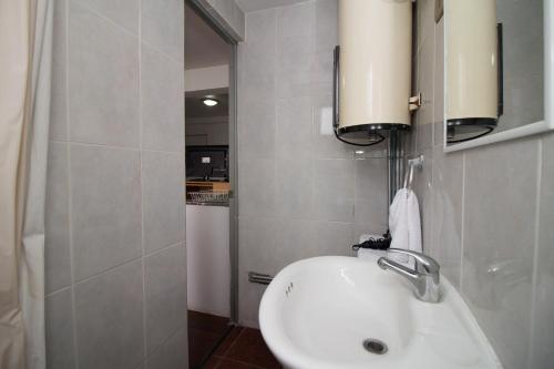 een badkamer met een witte wastafel en een spiegel bij JMJ Departamentos Amoblados Ocarrol in Rancagua