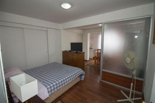 1 dormitorio pequeño con 1 cama y ventilador en JMJ Departamentos Amoblados Ocarrol, en Rancagua