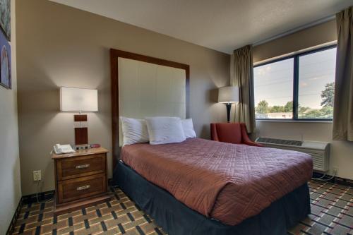 a hotel room with a bed and a window at Heritage Grand Inn in Canton
