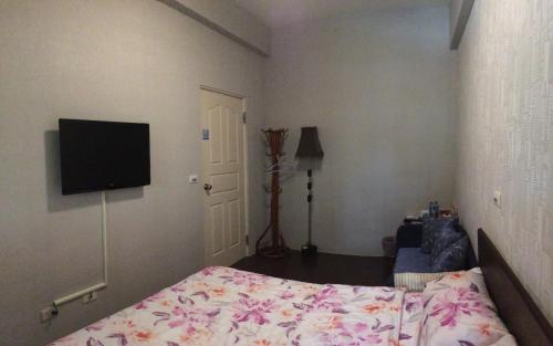 a bedroom with a bed and a flat screen tv at Fly House 飛航家民宿 in Hualien City