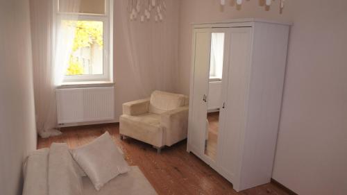 a bedroom with a white bed and white walls at Noclegi Wrzeszcz in Gdańsk