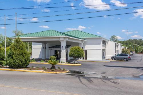 a large white building with a green roof at Motel 6 Waycross in Waycross