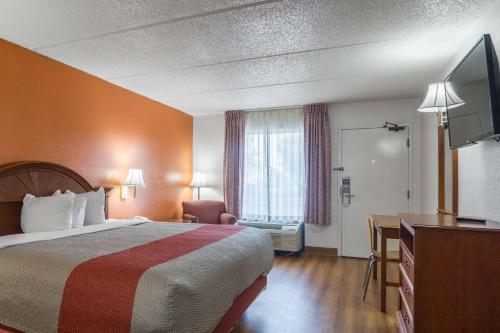 a hotel room with a bed and a television at Motel 6 Waycross in Waycross