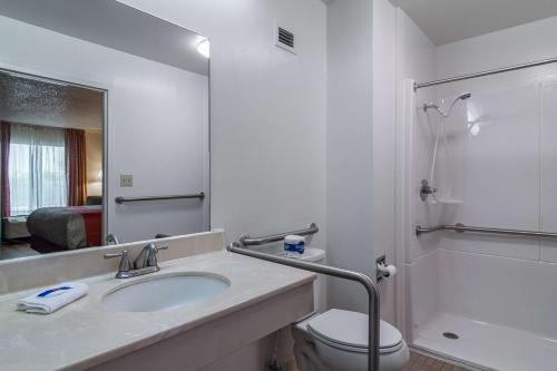 ウェイクロスにあるMotel 6 Waycrossの洗面台、トイレ、鏡のあるバスルーム