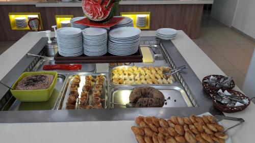 a buffet line with plates and pastries and food at Meropi Hotel & Apartments in Malia
