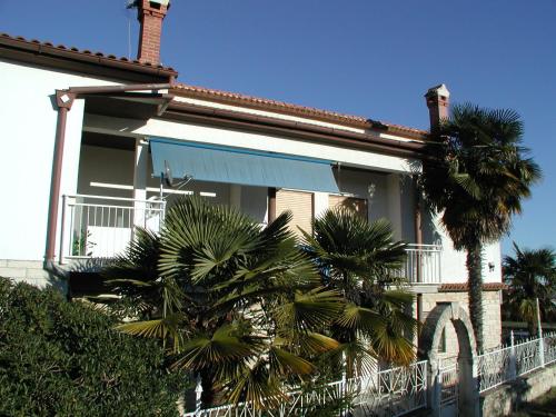 a house with palm trees in front of it at Blasco in Krnica