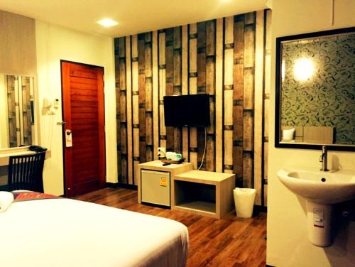 a bedroom with a bed and a sink and a television at P-Residence in Hat Yai