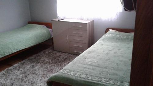 a bedroom with two twin beds and a dresser at Dena apartman Tivat in Tivat