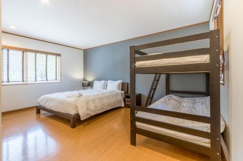 1 Schlafzimmer mit 2 Etagenbetten und 1 Bett in der Unterkunft Kiseki in Niseko