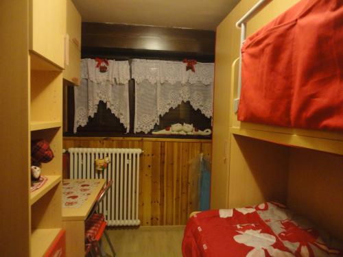 a small room with a bed and a window at Sella Ronda Apartment in Campitello di Fassa