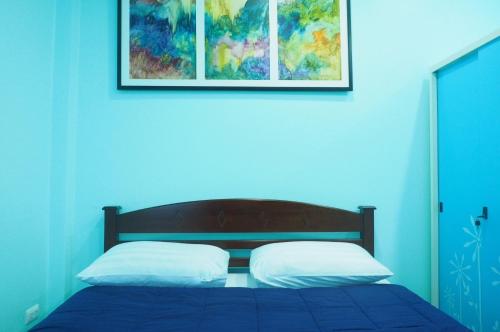 a blue bedroom with a bed with two white pillows at Phuket Best Travel in Nai Yang Beach