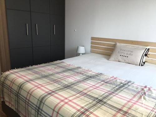 a bedroom with a bed with a plaid blanket at Apartments Helios in Pomorie