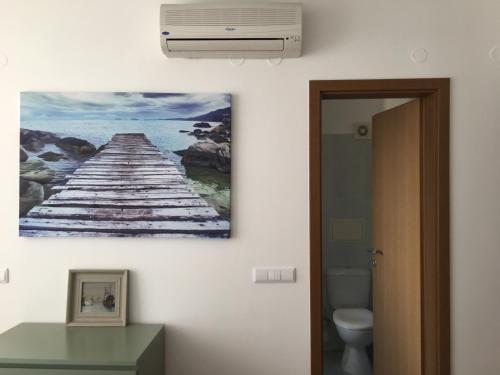 a bathroom with a picture of a pier on the wall at Apartments Helios in Pomorie