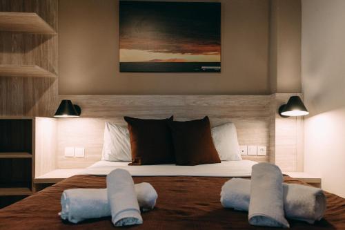 ein Schlafzimmer mit einem Bett mit zwei Kissen darauf in der Unterkunft Kymata in Palaiopoli
