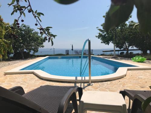 a swimming pool with some chairs and a table at Holiday Home Oleja in Split