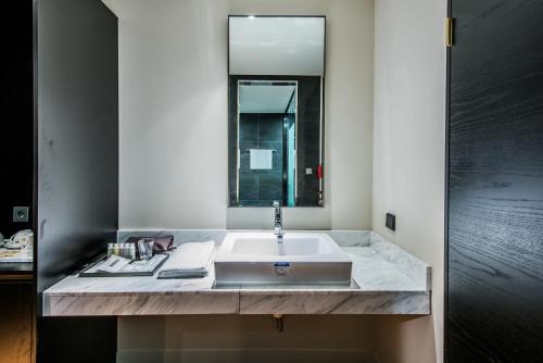 a bathroom with a sink and a mirror at Rivertain Hotel in Daegu