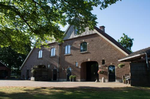 a large red brick building with a large doorway at B&B Erve de Bosch in Benteloo