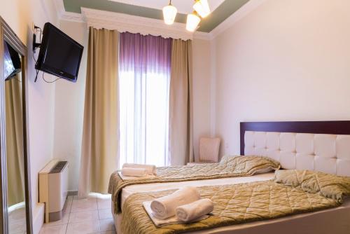 a bedroom with a bed with two towels on it at Hotel Zografos in Paralia Katerinis