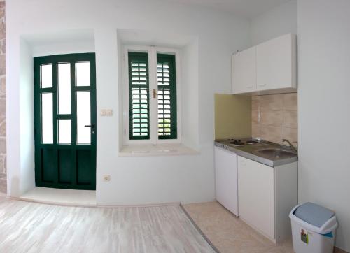 a kitchen with white walls and green doors at Apartments Galić in Split