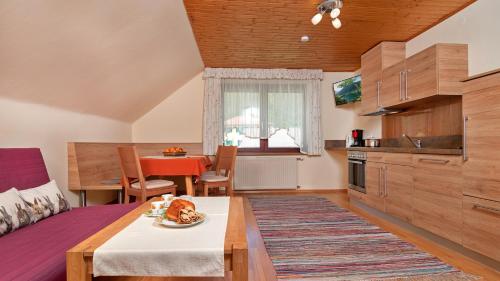 Sonnhof في فيلاخ: مطبخ وغرفة معيشة مع كلب على طاولة