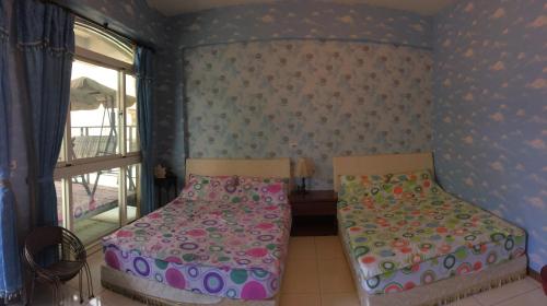 a bedroom with two beds and a window at Fly House 飛航家民宿 in Hualien City