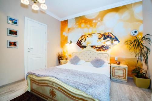 a bedroom with a bed and a painting on the wall at Pensiunea Avy in Haţeg