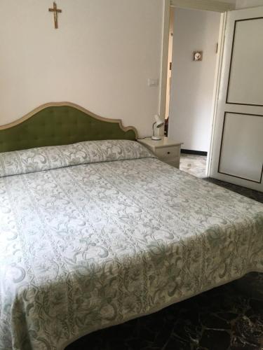 Jolie Maison في سانتا مارغريتا ليغور: غرفة نوم مع سرير مع صليب على الحائط