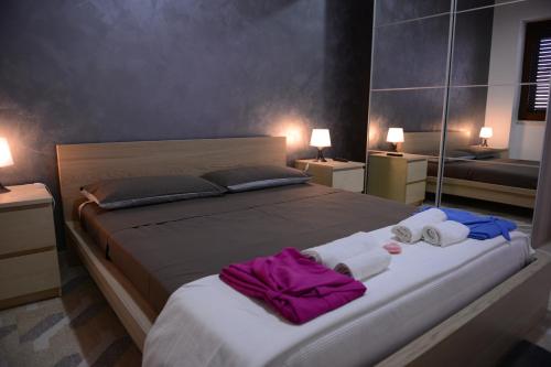 a bedroom with a large bed with towels on it at Bed & breakfast "MAZZINI" in Leverano