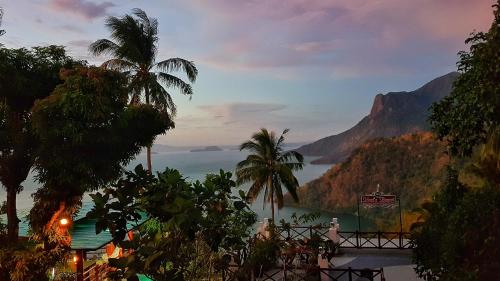 a view of the ocean from a resort with palm trees at Noni's Resort in Alitagtag