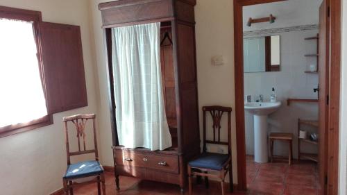een badkamer met een wastafel, een spiegel en 2 stoelen bij Mas del Tancat in Amposta