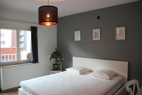 una camera con un letto bianco e una finestra di Royal Plage Oostende a Ostenda