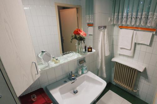 a white bathroom with a sink and a mirror at Apartma AS in Lesce