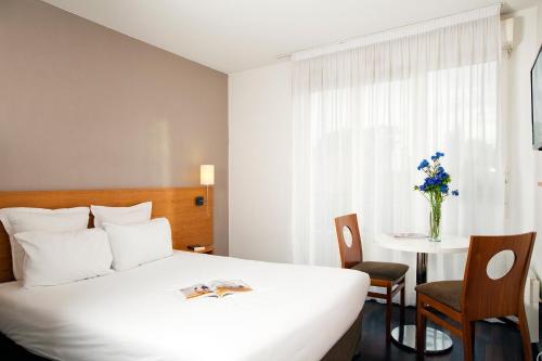 Ένα ή περισσότερα κρεβάτια σε δωμάτιο στο Séjours & Affaires Paris-Nanterre