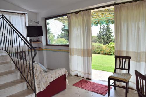a living room with a staircase and a window at Battistina Holiday Home in Costa Rei