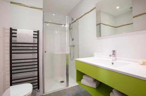 un baño con lavabo y ducha en Bel Ombra Hôtel, en Bandol