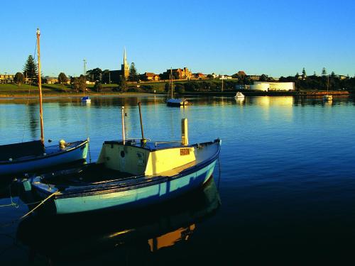 two boats are docked in a body of water at NRMA Portland Bay Holiday Park in Portland