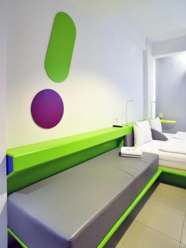 a room with a bed with green and purple at POP! Hotel Tebet Jakarta in Jakarta