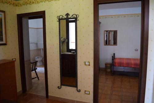 a room with a mirror and a bedroom with a bed at Battistina Holiday Home in Costa Rei